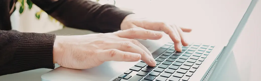 mains posées sur le clavier d'un ordinateur portable, lumière douce