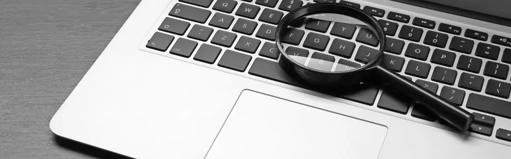 loupe posée sur le clavier d'un ordinateur portable